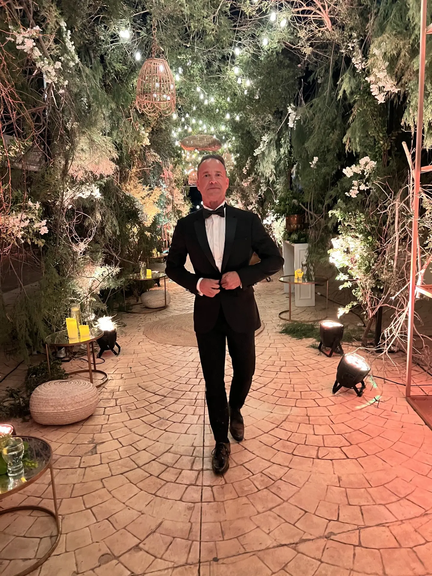 Rob Steven Williams in a black tuxedo at an evening garden event